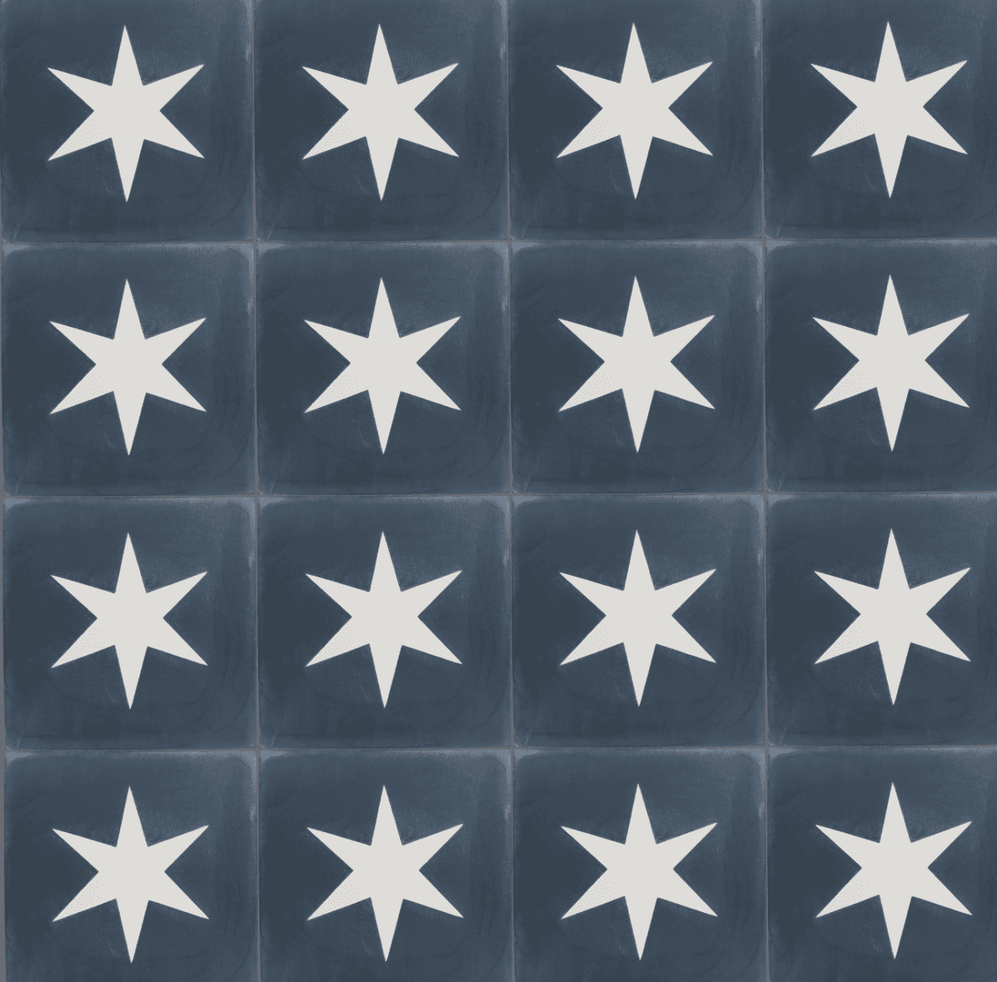 a surface of blue tiles with white star designs on them.