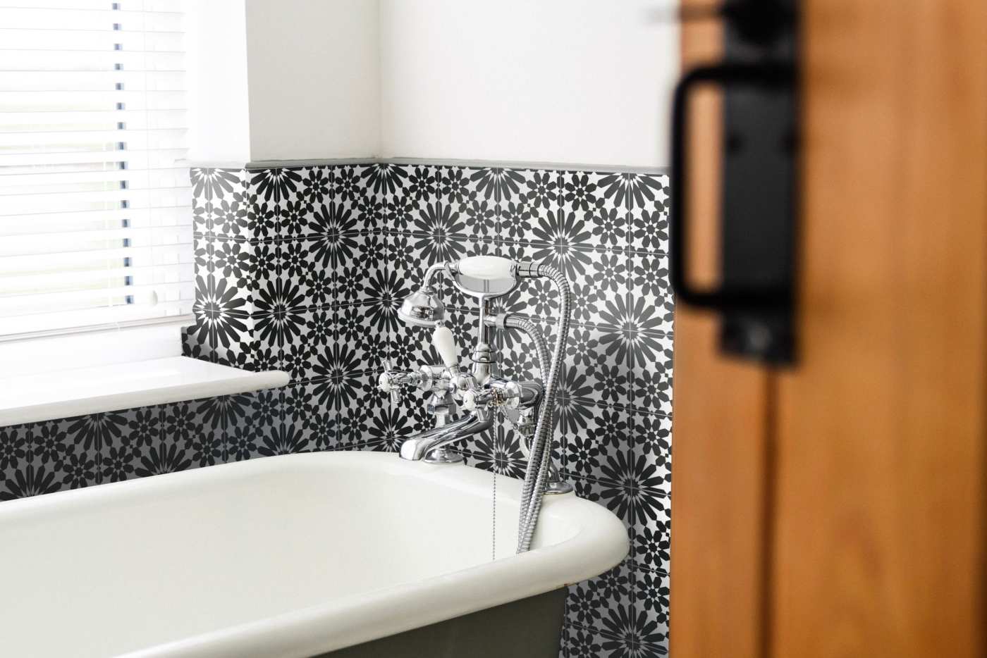 a bathroom with a black and white tiled wall.