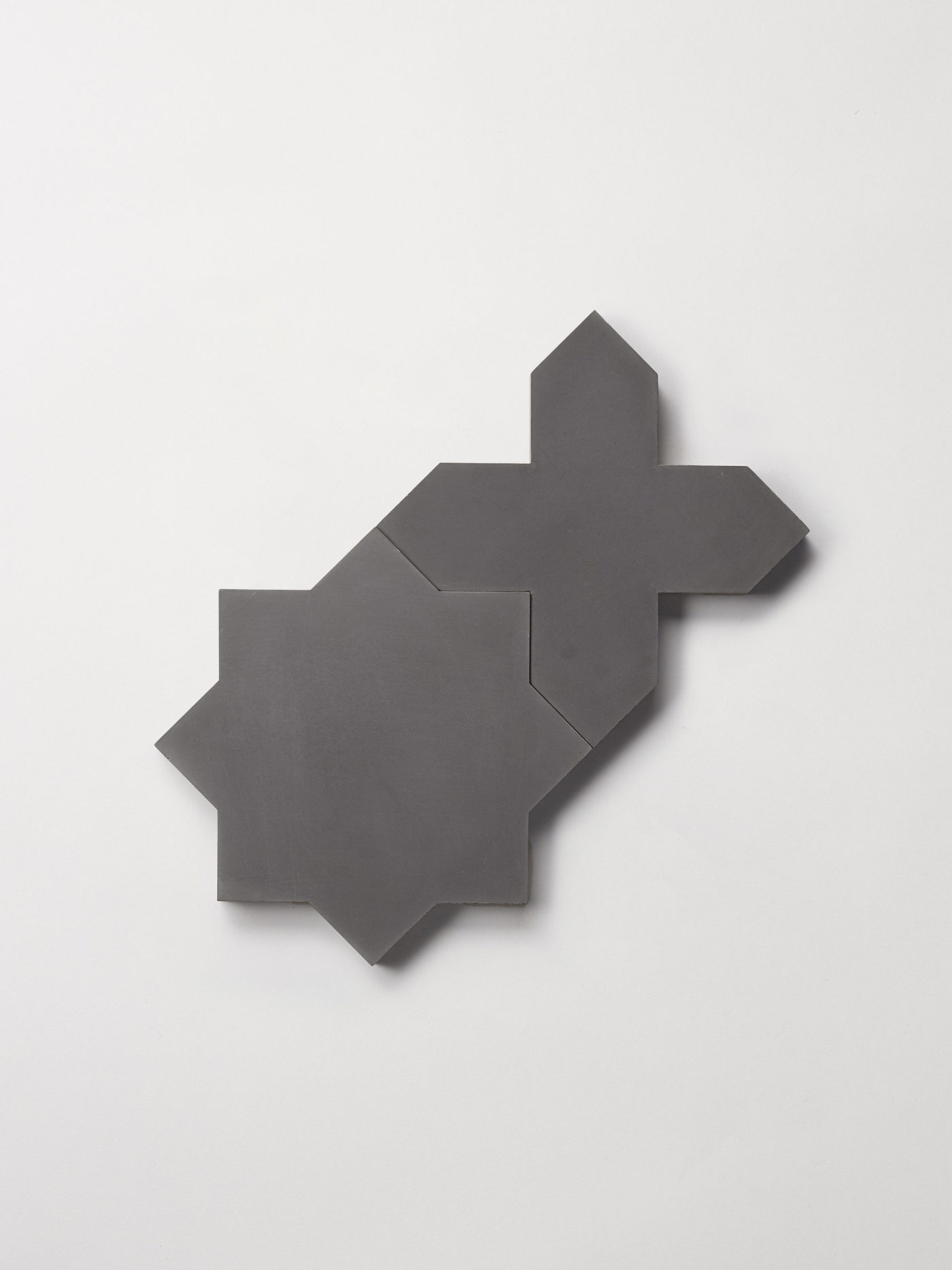 a set of black star and cross shaped tiles on a white backdrop.