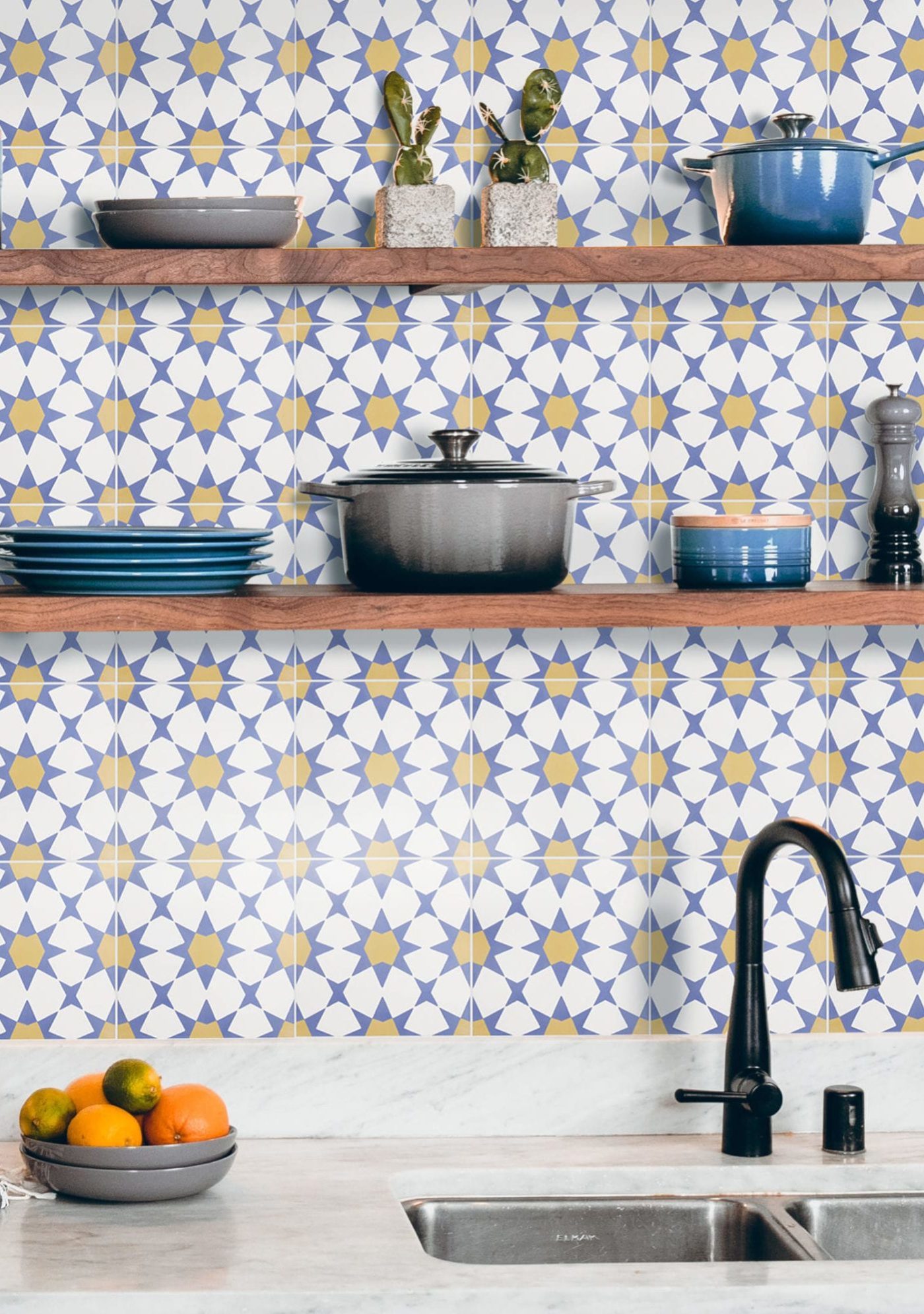 a kitchen with blue, white, and yellow tiles on the sink backsplash.