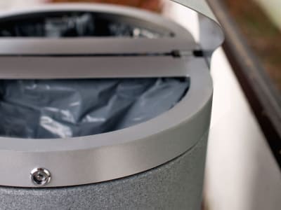 closeup of a double stream outdoor metal and plastic waste and recycling container with a silver sparkle finish and large grey plastic liners