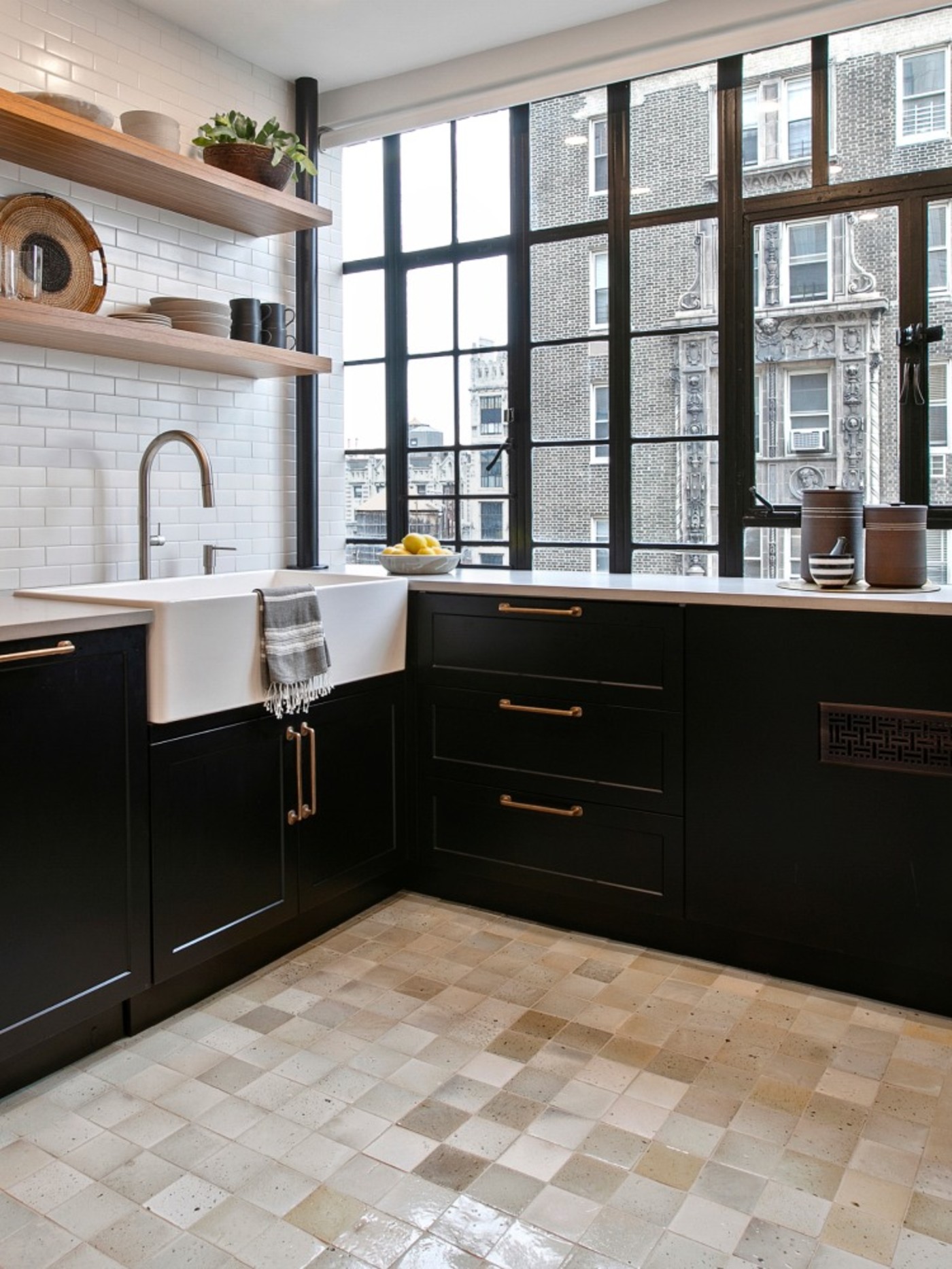 a kitchen with black cabinets and a tile floor.