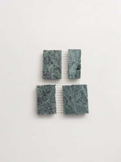 four pieces of green marble on a white surface.