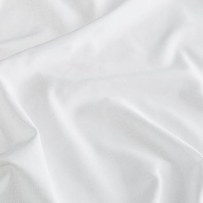 White satin fabric spread across a surface, rumpled into gentle folds and creases that catch soft diffuse light, close-up view with a neutral background.