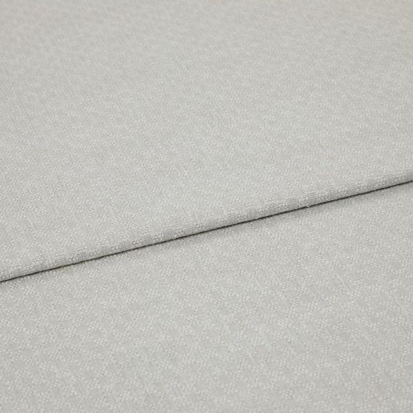 Light grey textured fabric panels overlapping slightly; top panel folded along a seam. Close-up view emphasizing woven pebble pattern, soft matte lighting, minimal background, studio-like neutral setting.