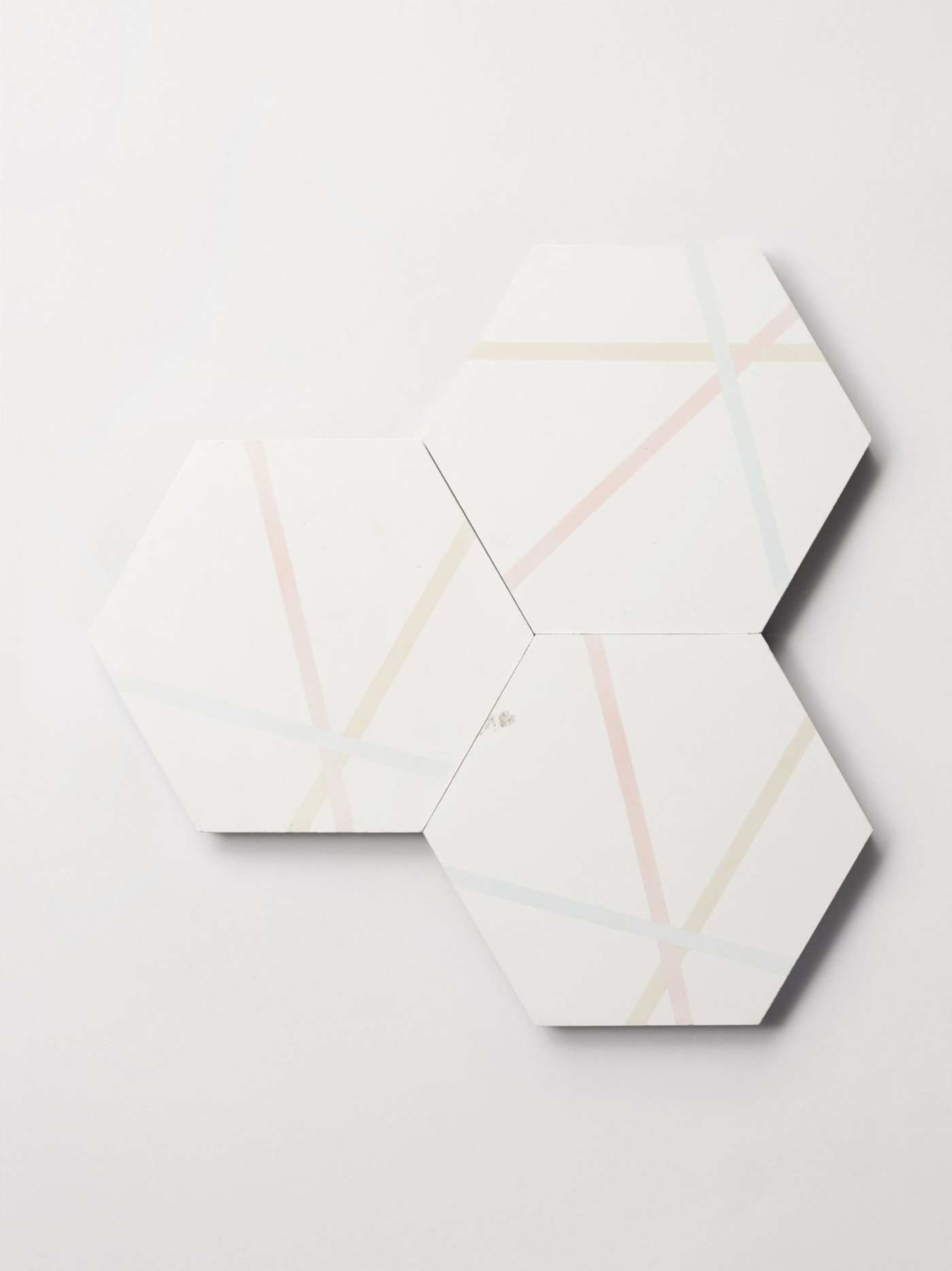 three white hexagonal tiles with multicolored lines on a white background.