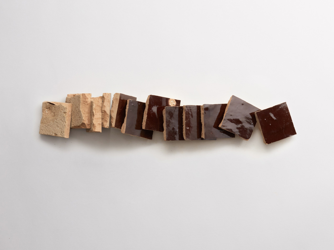 brown tiles stacked on a white surface.