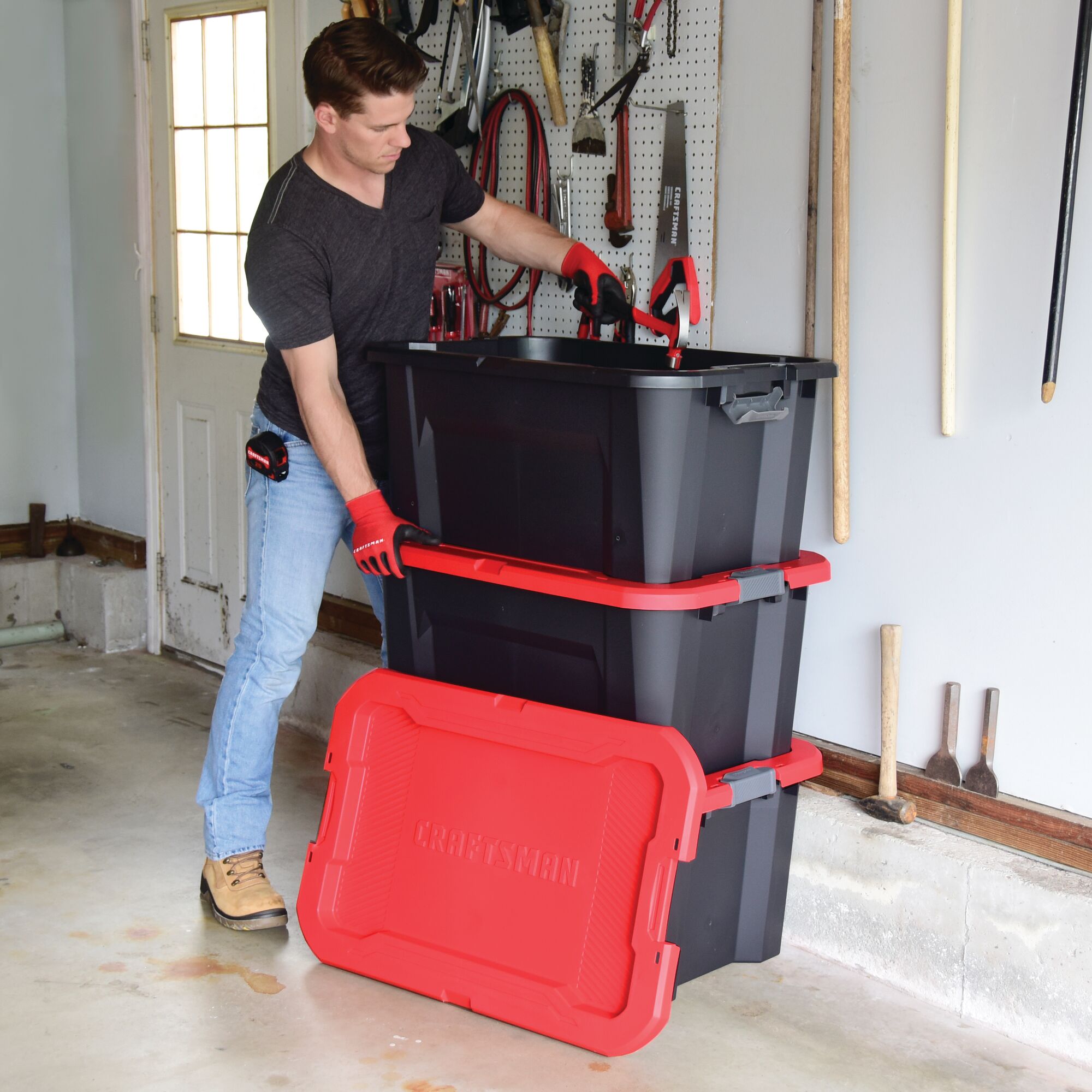30 Gallon latching tote being used by a person to stack multiple bins.