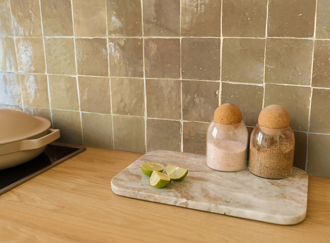 a kitchen counter with a tiled backsplash, cutting board and a set of salt and pepper shakers.