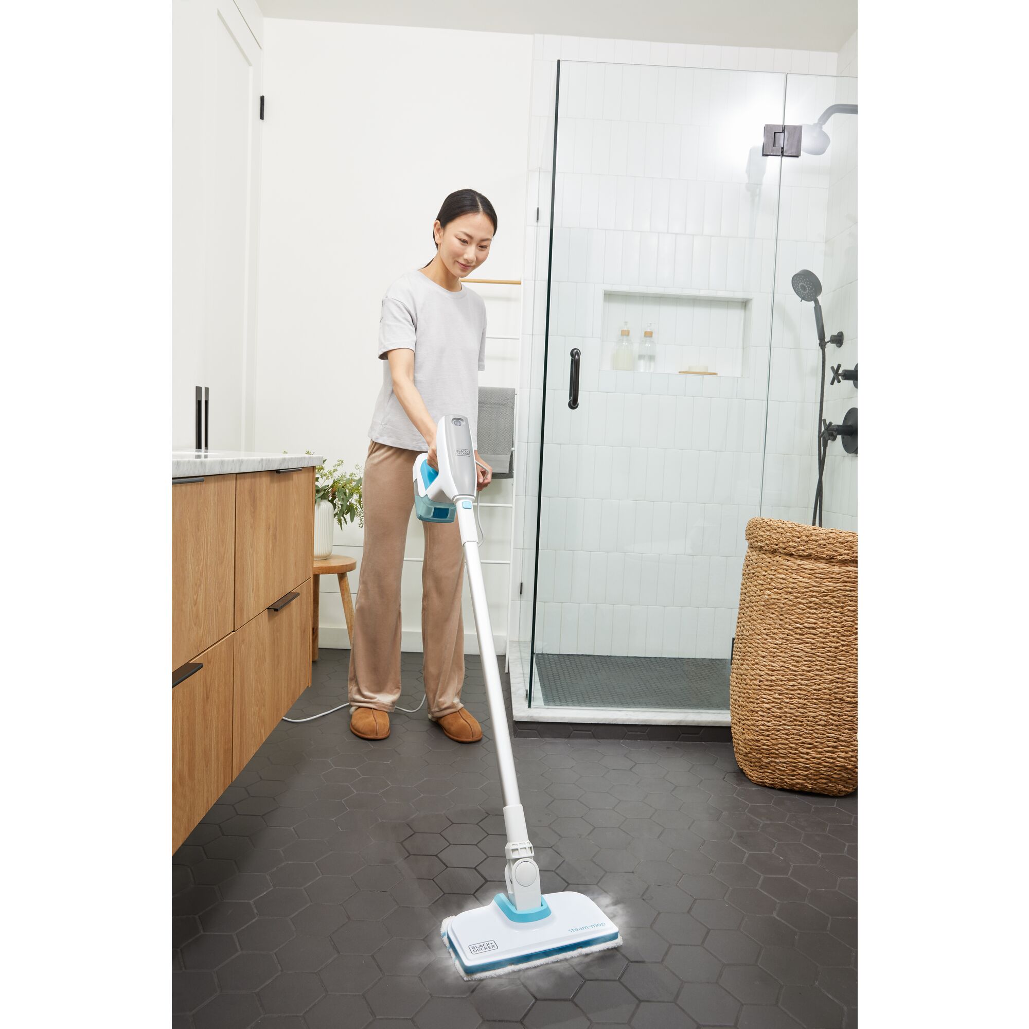 Woman cleaning bathroom floor with steam mop