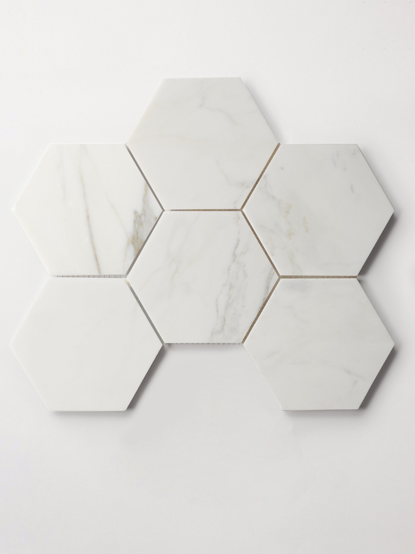 a sheet of white marble hexagon tiles on a white surface.