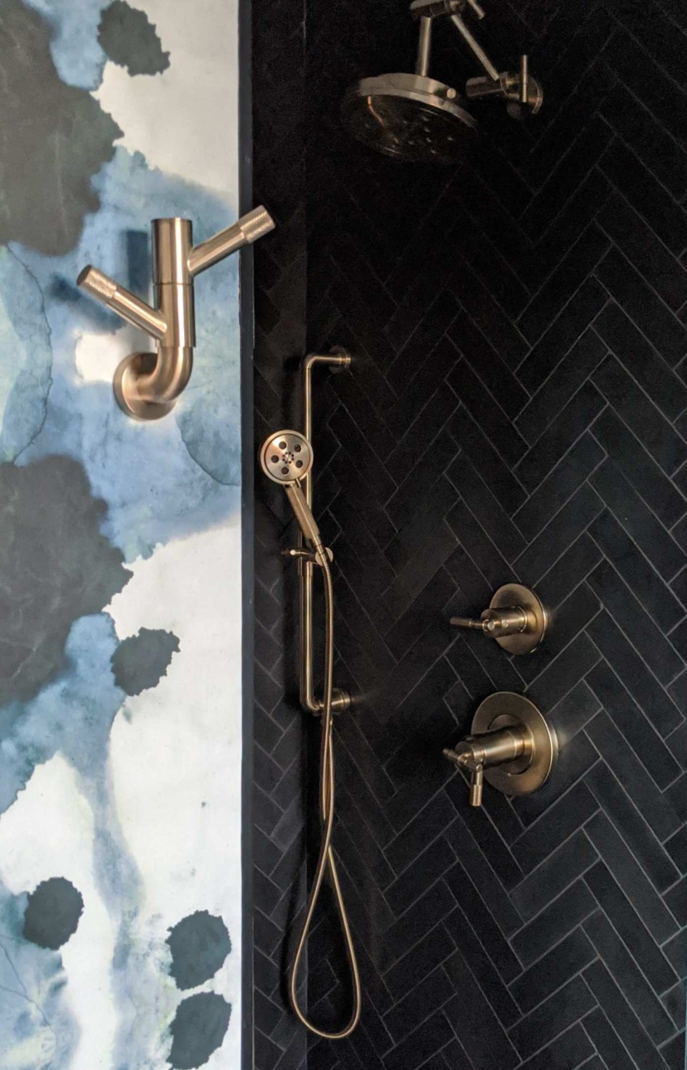 a black and blue shower with a brass shower head.