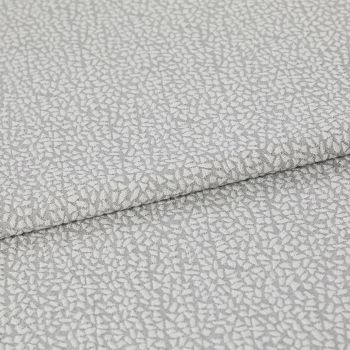 Light-gray, pebble-patterned upholstery fabric folded once, textured with a subtle metallic sheen; close-up view on a neutral surface under soft, diffuse lighting.