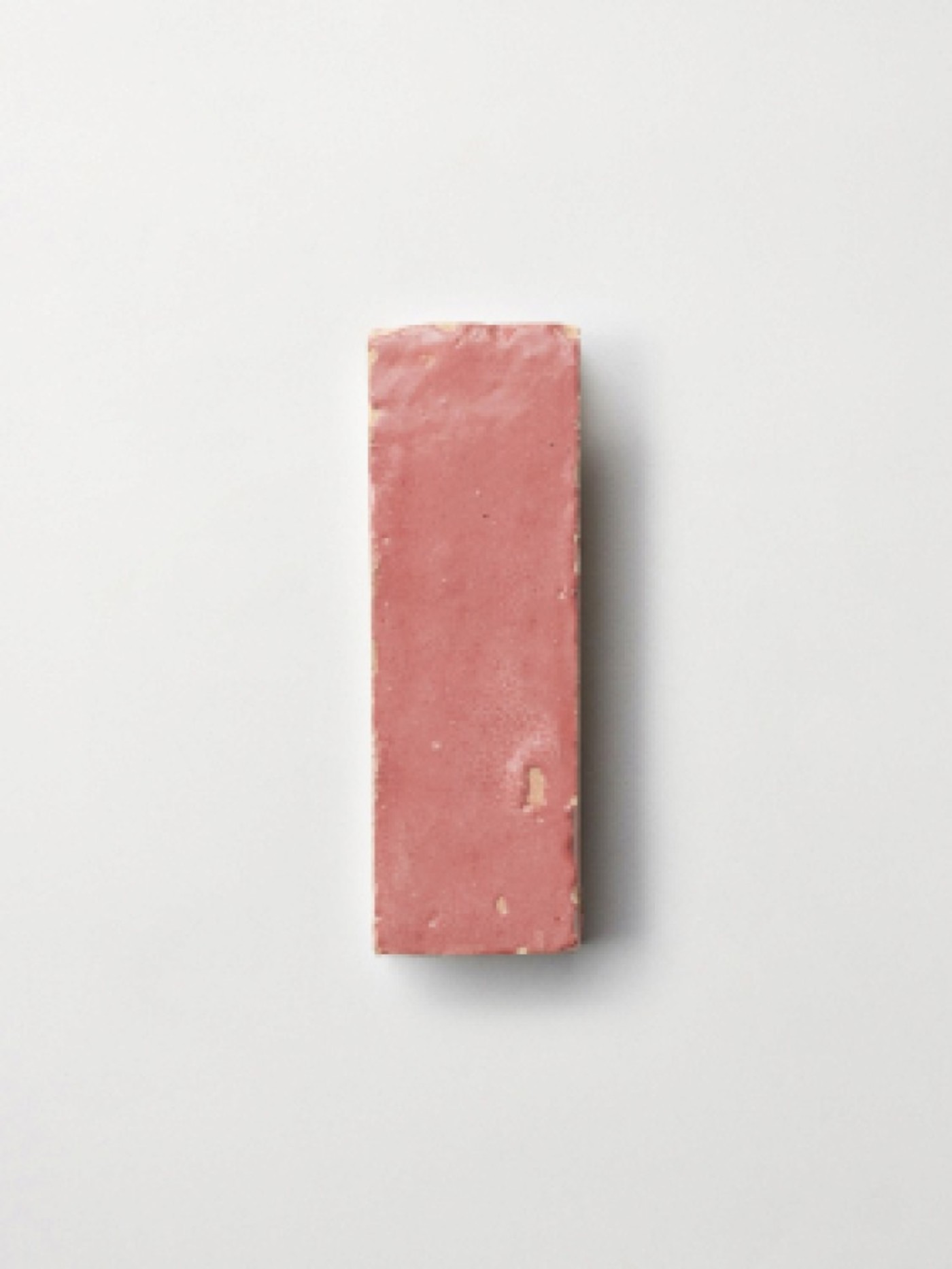 a pink rectangular tile on a white surface.