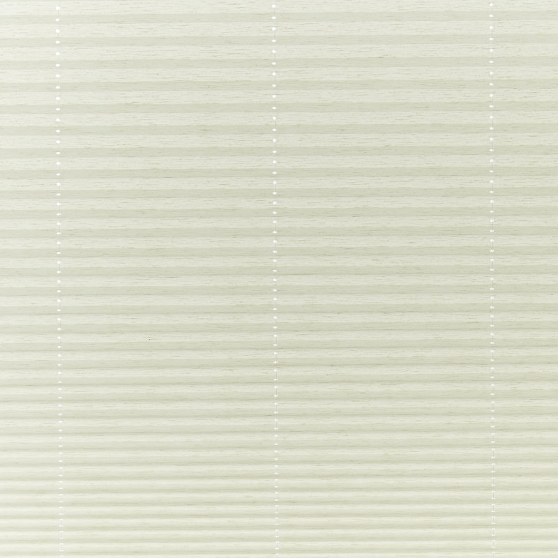 Cream cellular pleated blinds covering the window, closed and gently filtering soft daylight; three faint vertical cord lines with small white grommets, neutral interior lighting.