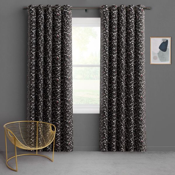 Floor-length charcoal curtains with grommets, white triangle pattern and red accents, pulled aside to reveal a bright window; gray room with a gold wire chair and small abstract framed print.