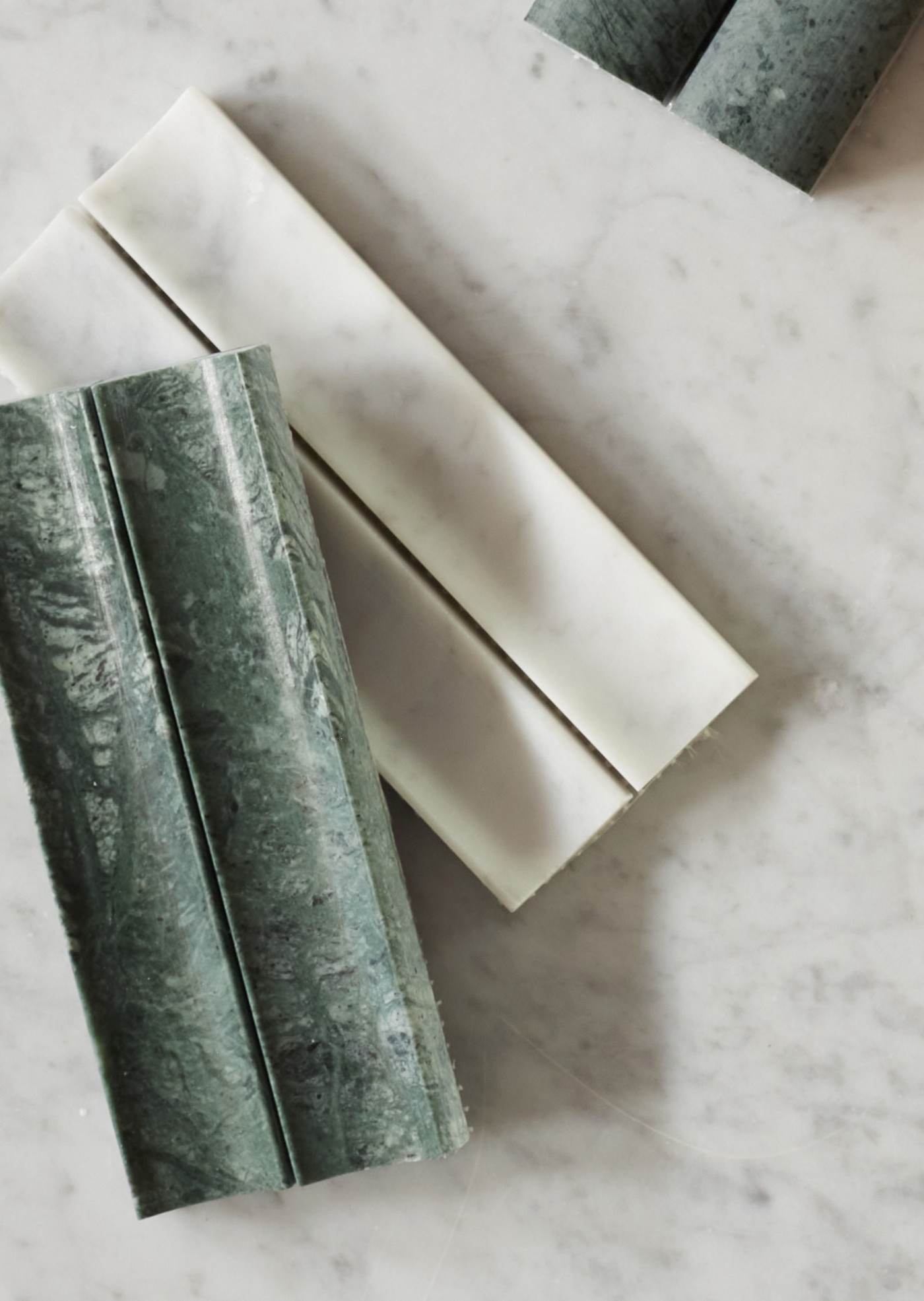 three green and white marble tiles on a marble table.