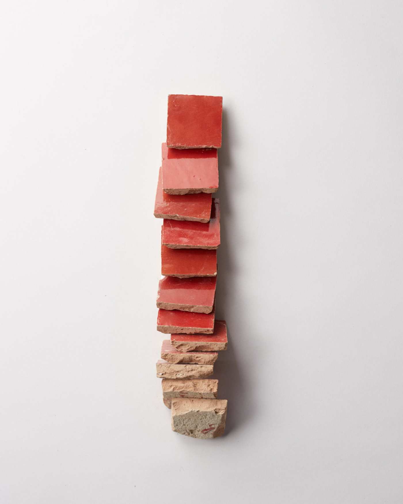 a stack of red tiles on a white surface.