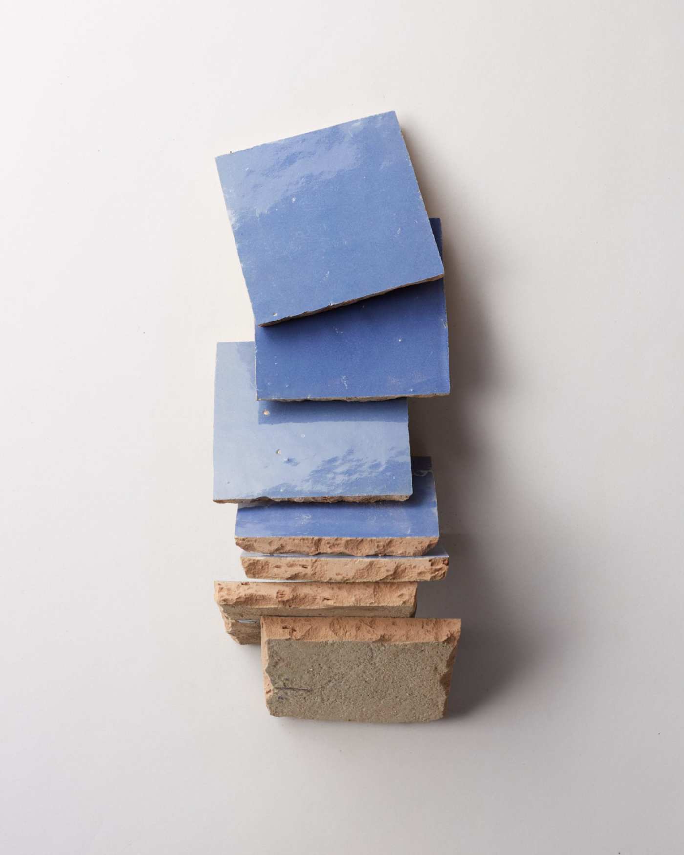 a stack of blue tiles on a white surface.