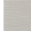 White pleated honeycomb (cellular) blind, fully lowered with visible hexagonal cells at left edge, closed and softly filtering light, close-up interior view with neutral lighting.