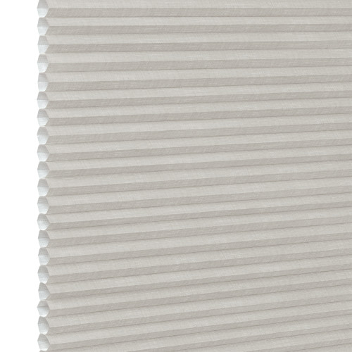 White pleated honeycomb (cellular) blind, fully lowered with visible hexagonal cells at left edge, closed and softly filtering light, close-up interior view with neutral lighting.