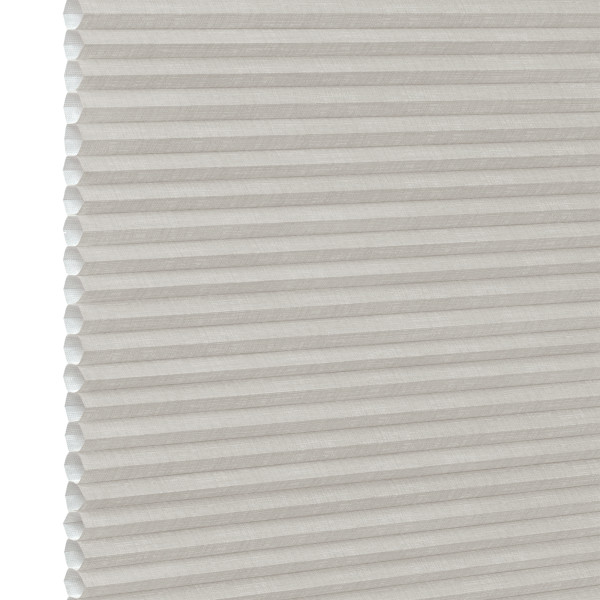 White pleated honeycomb (cellular) blind, fully lowered with visible hexagonal cells at left edge, closed and softly filtering light, close-up interior view with neutral lighting.