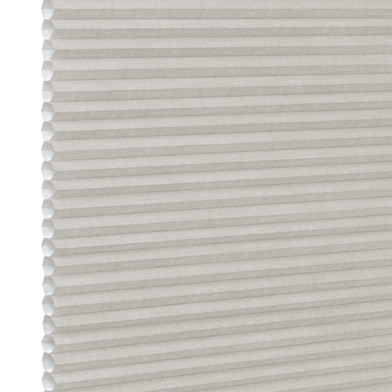 White pleated honeycomb (cellular) blind, fully lowered with visible hexagonal cells at left edge, closed and softly filtering light, close-up interior view with neutral lighting.