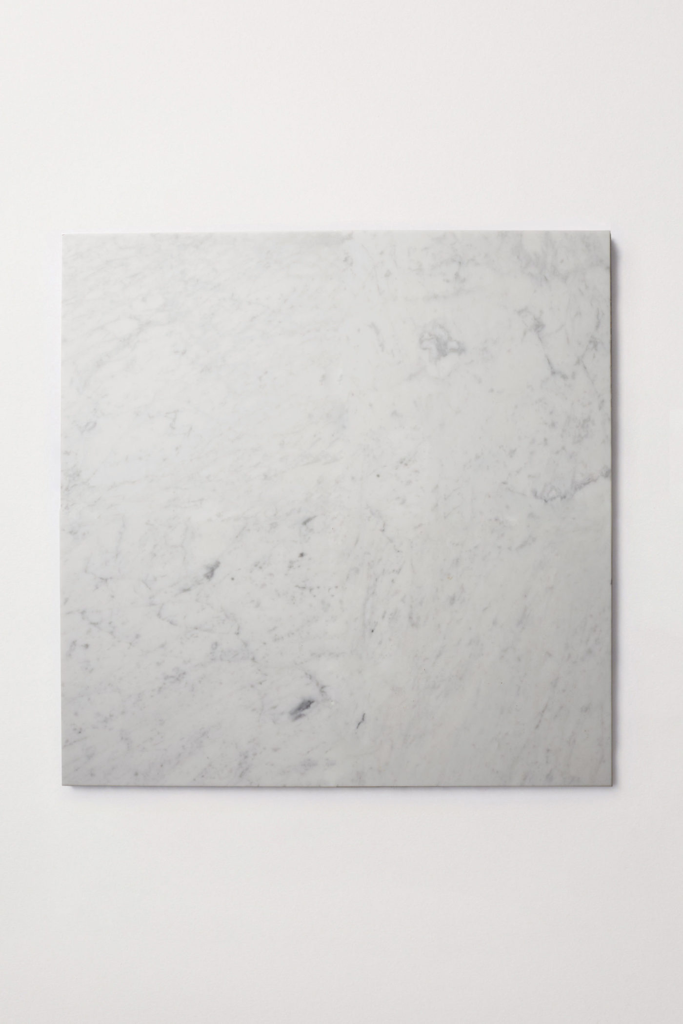 a white marble square on a white surface.