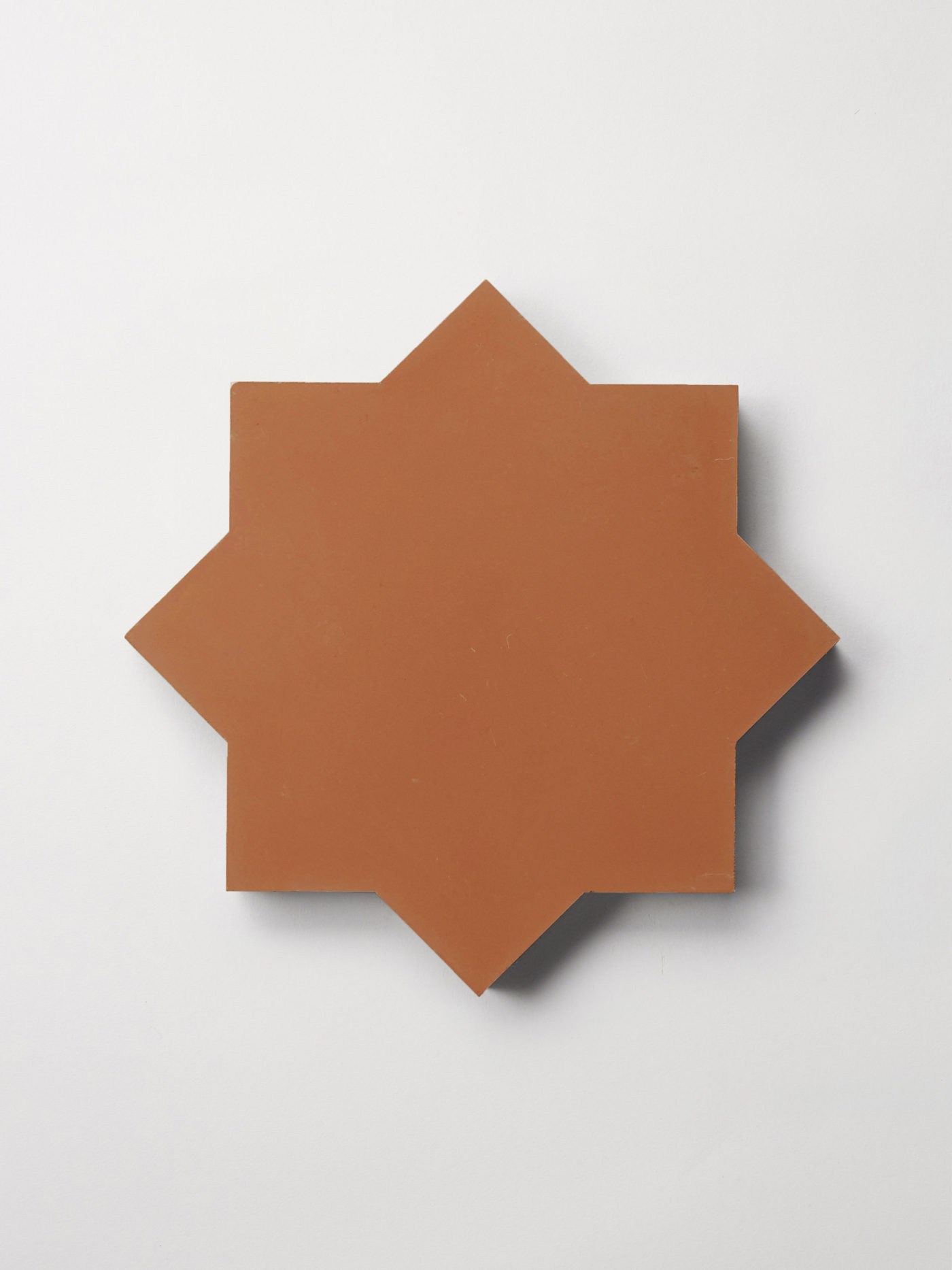 a red star-shaped tile on a white surface.