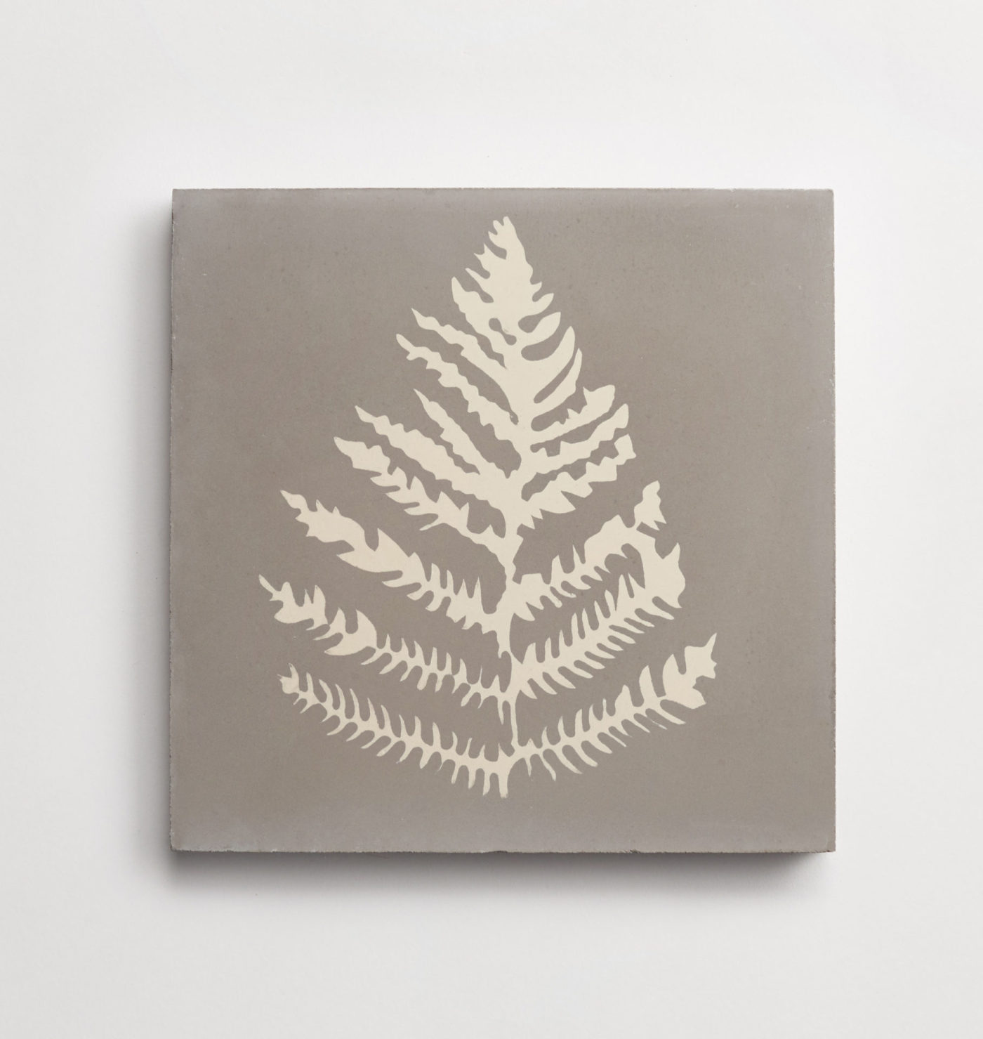 a grey tile with a white fern leaf pattern on it.