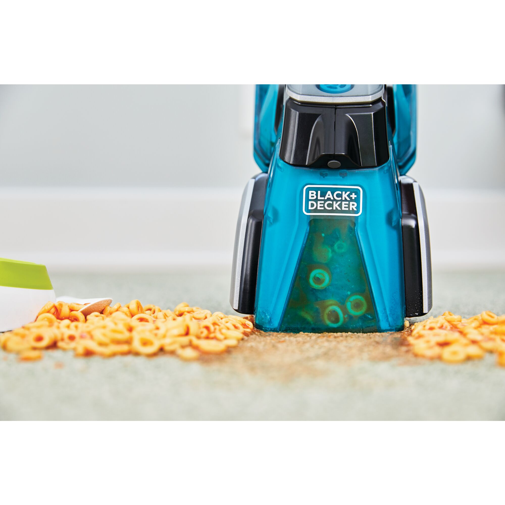 Black and decker Spillbuster Cordless Spill And Spot Portable Carpet Cleaner being used by a person to clean up spaghettios from a light colored floor
