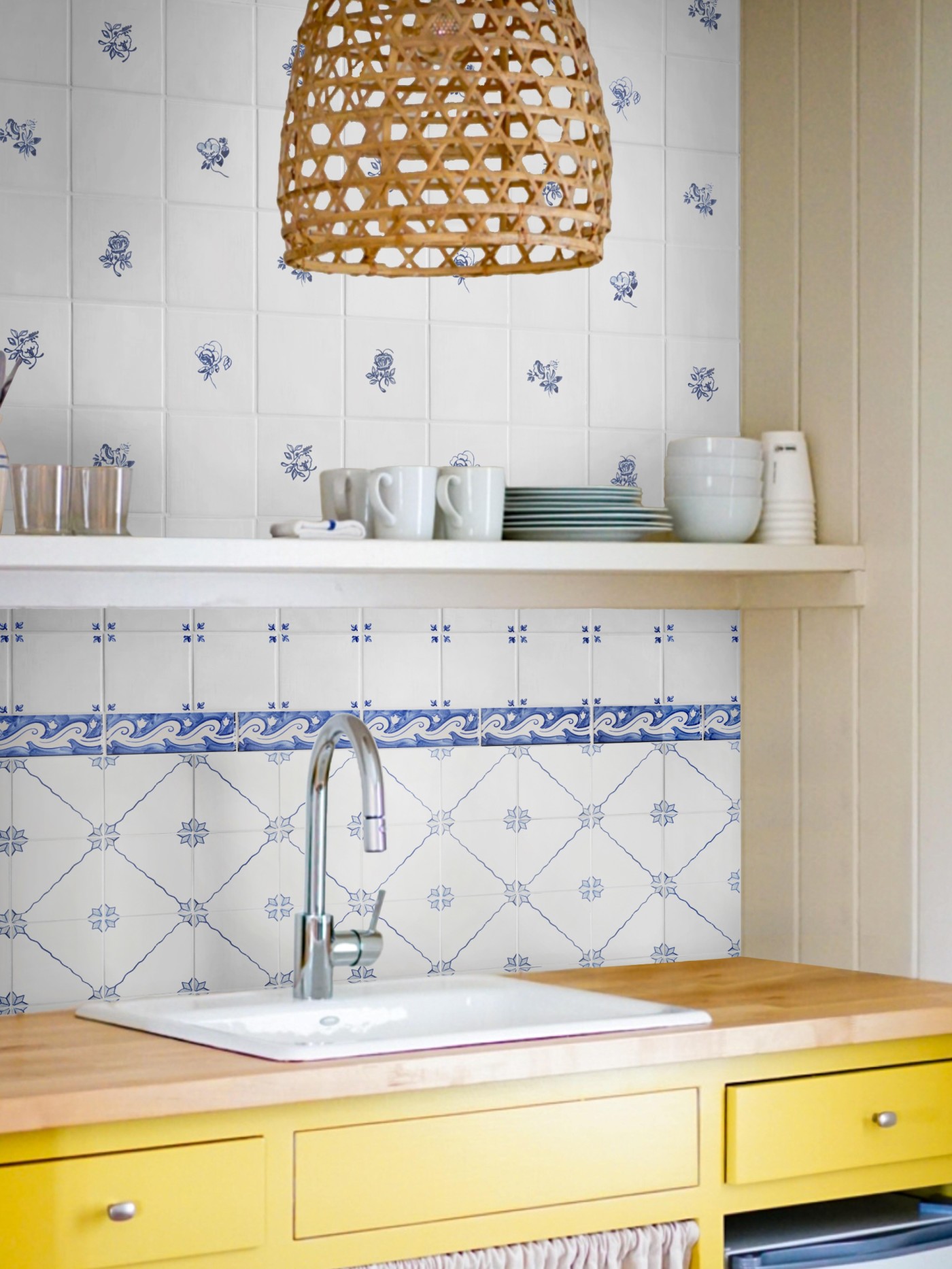 a yellow kitchen with blue and white tiles.