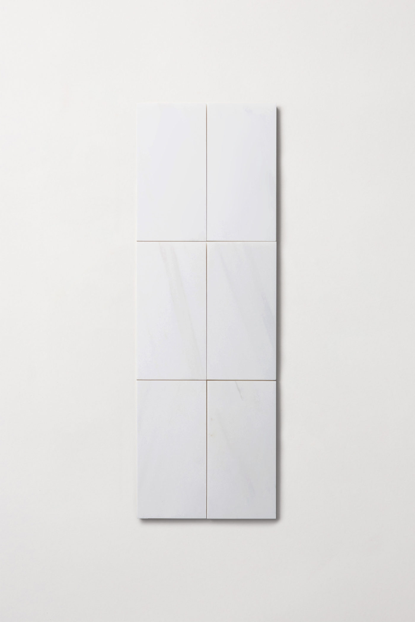 three white square tiles on a white surface.