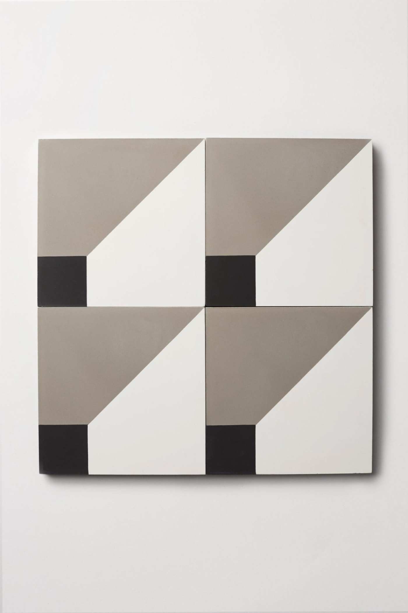 four white and grey tiles with black squares on them.