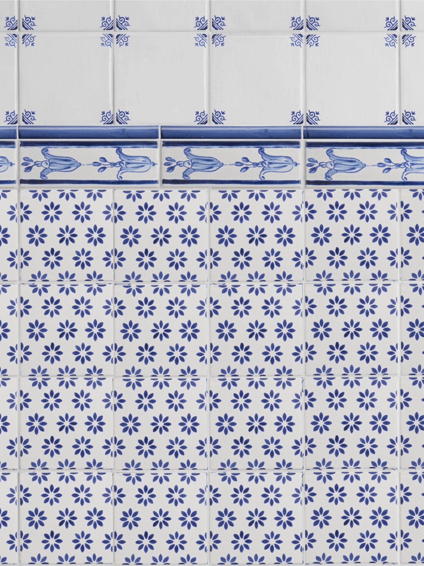 a blue and white tiled wall with floral designs.