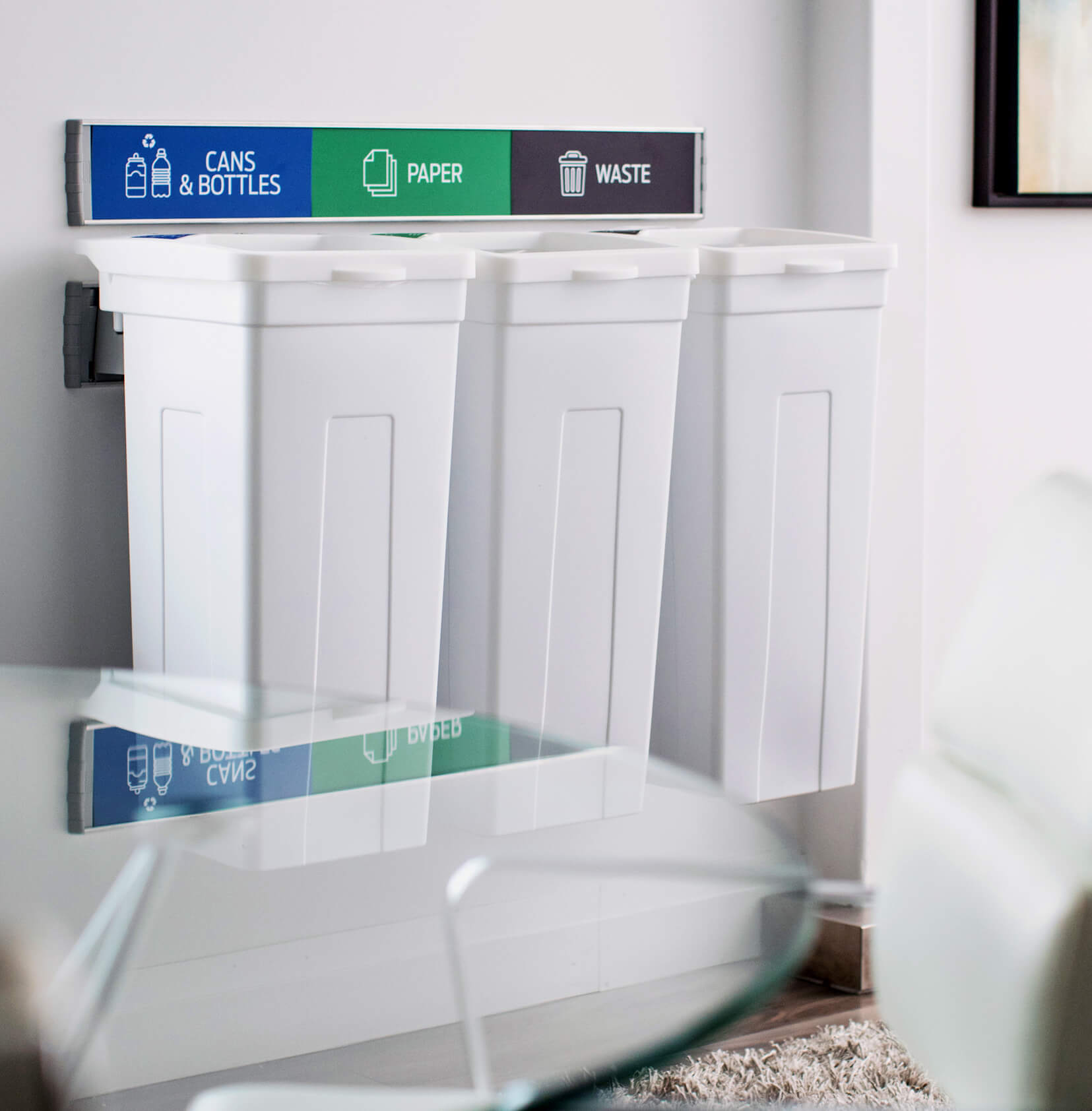 white triple wall hanging waste and recycling bins with signs and labels in an upscale office