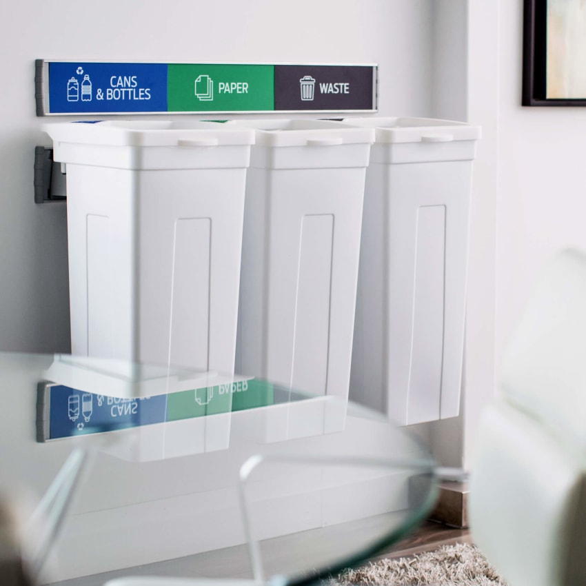 white triple wall hanging waste and recycling bins with signs and labels in an upscale office