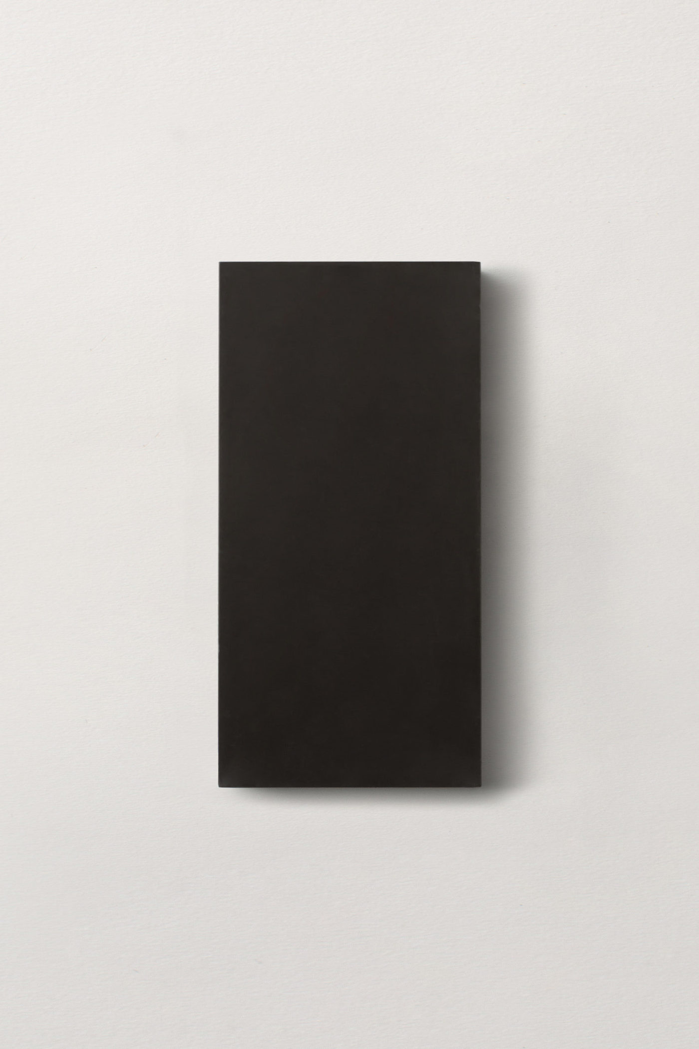 a black rectangle tile on a white surface.