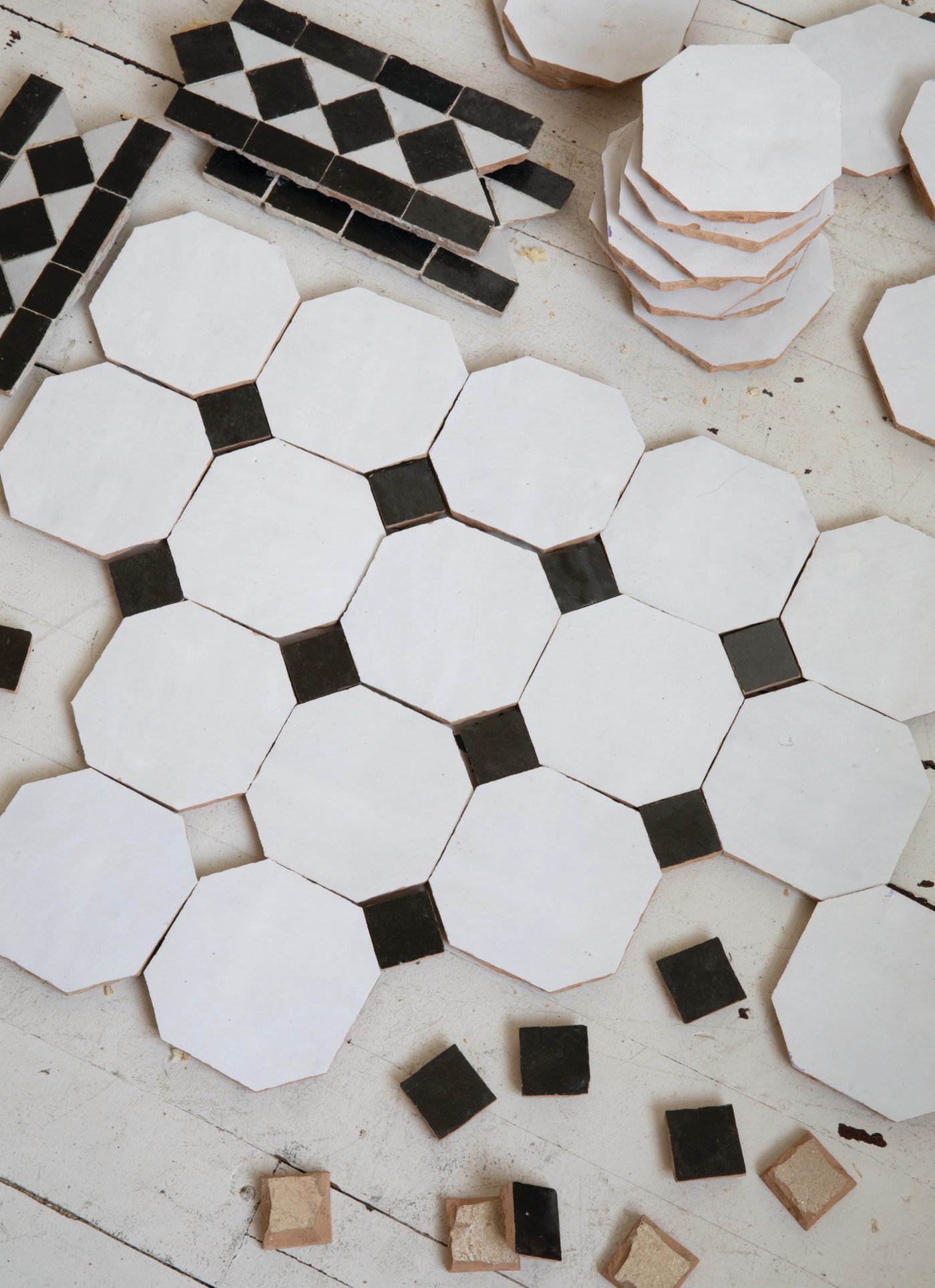 black and white tiles laid out on a white surface.