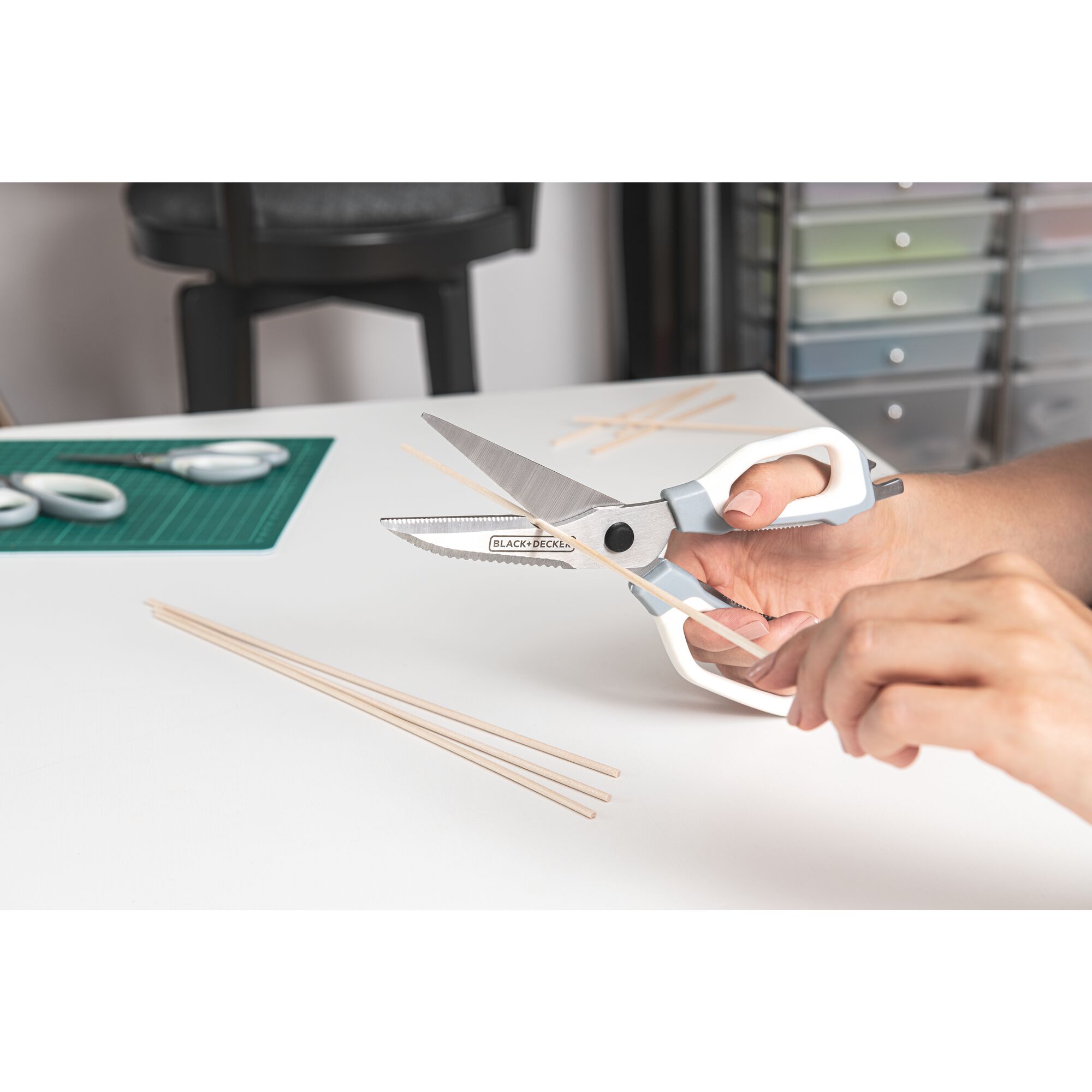 BLACK+DECKER crafting shears being used to cut 1/8-in. wooden dowel in a crafting room