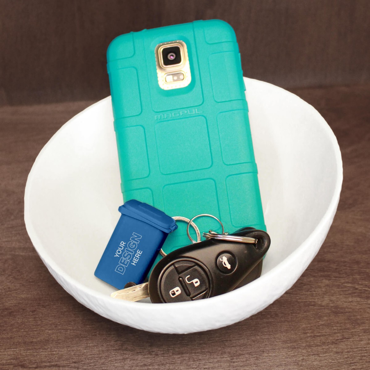 mini promotional blue recycling cart keychain sitting in a bowl with keys attached and a teal cell phone case