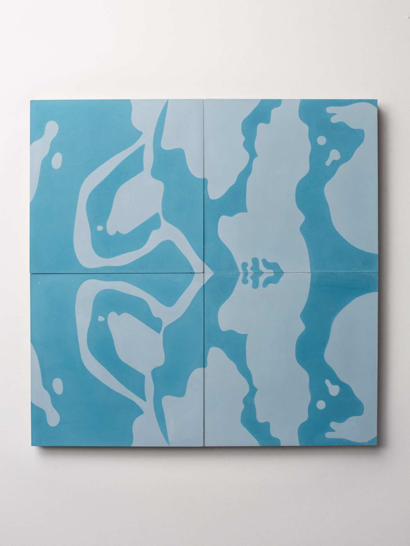 four blue patterned tiles on a white surface.