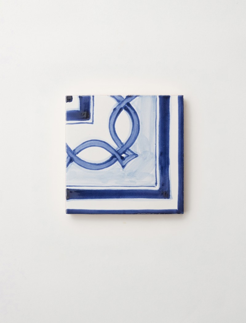 a blue and white tile with a design on it.