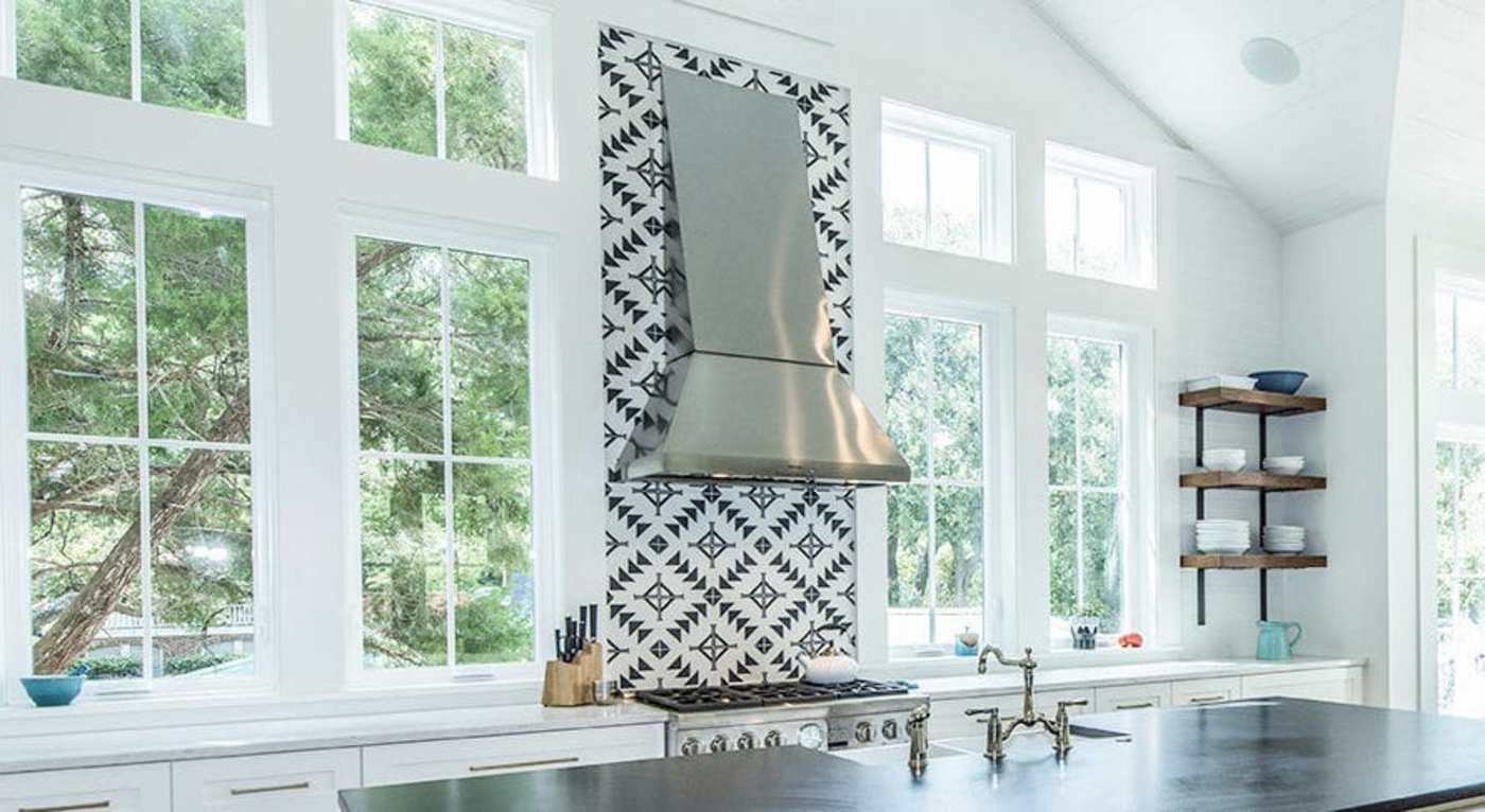 a white kitchen with black and white tile.