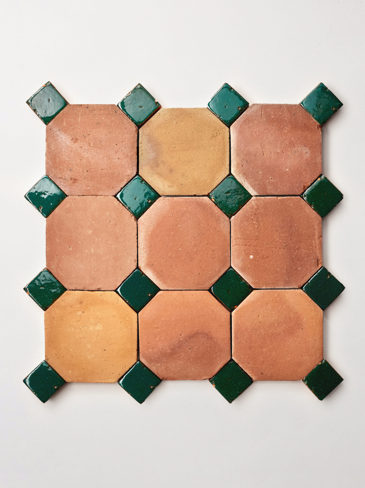 green and terracotta tiles in a pattern on a white background.