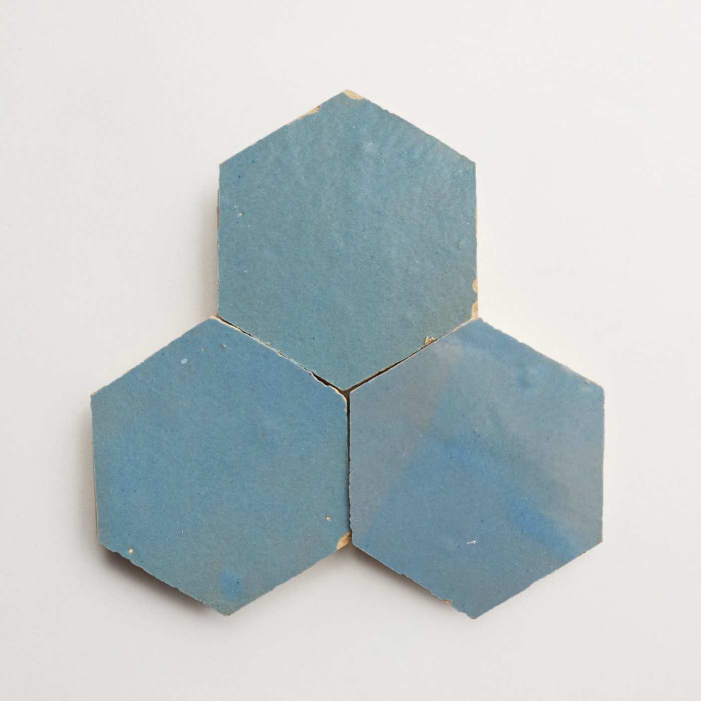 three blue hexagon tiles on a white surface.