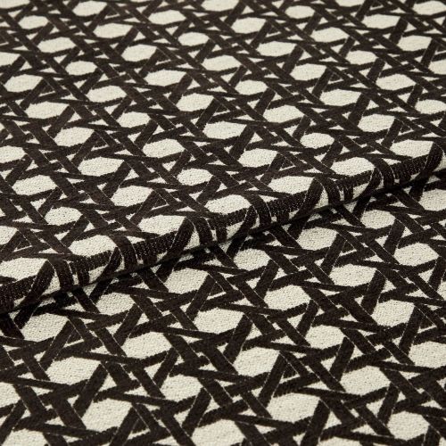 Woven beige fabric with dense black geometric lattice pattern, folded over itself; repeating circular-and-cross motif, textured upholstery cloth displayed flat under neutral studio lighting.