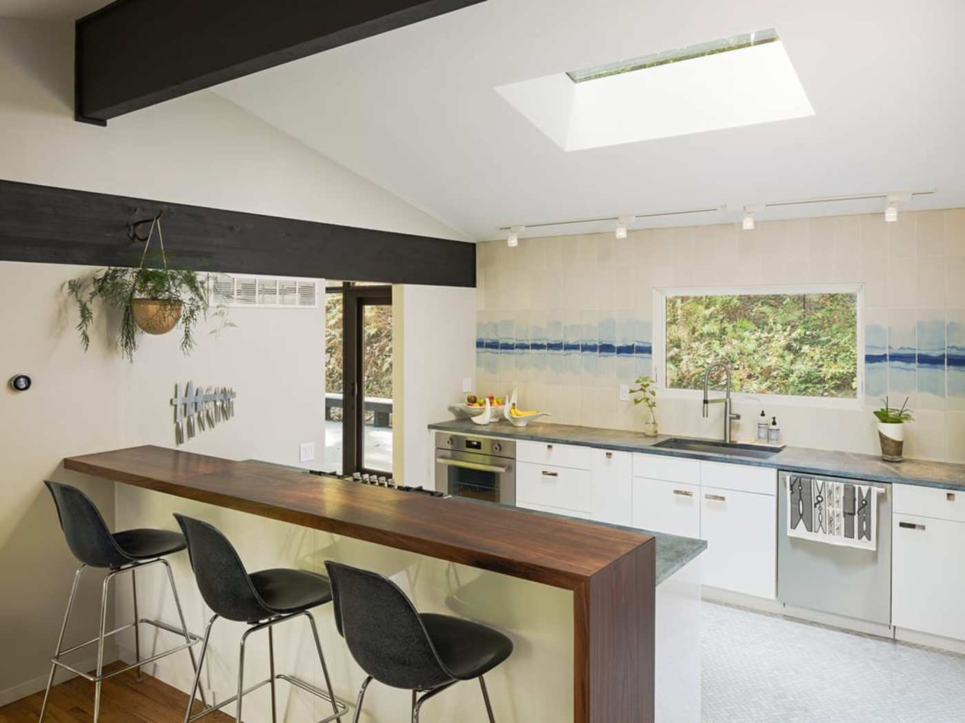 a kitchen with a skylight and bar stools.