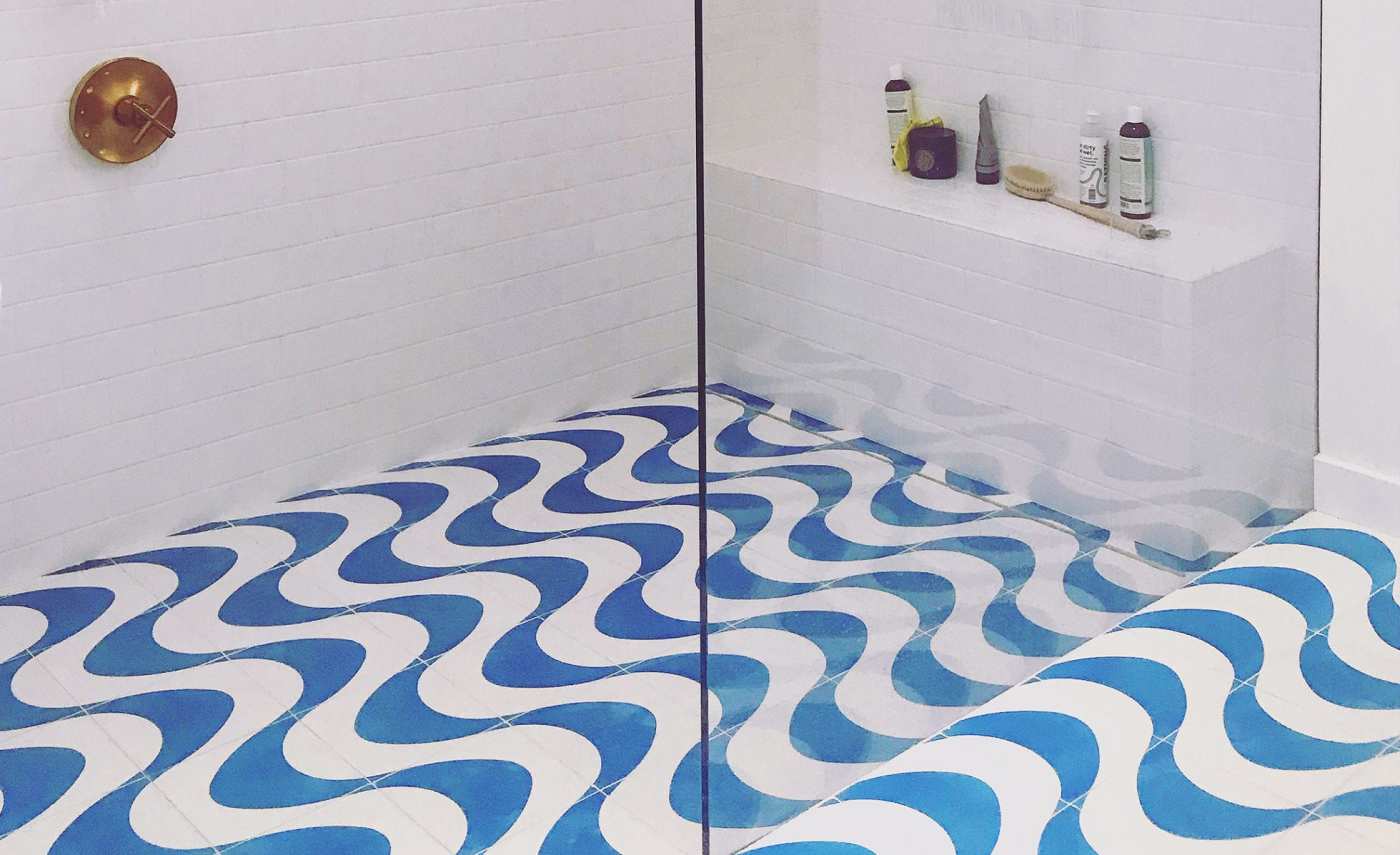 a shower with a blue and white tiled floor.