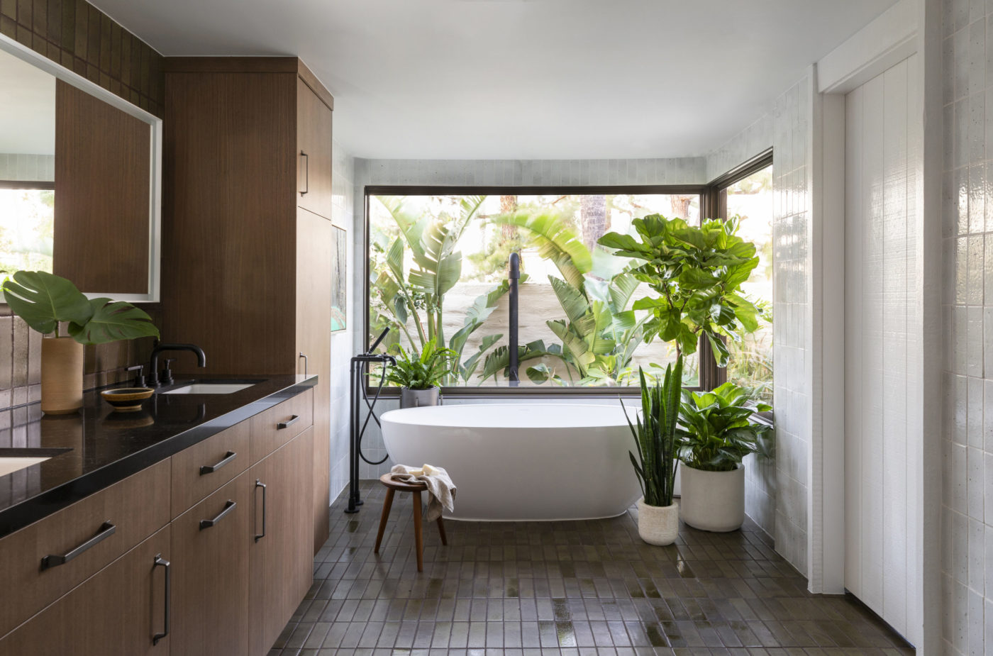 a modern bathroom with a tub and plants.